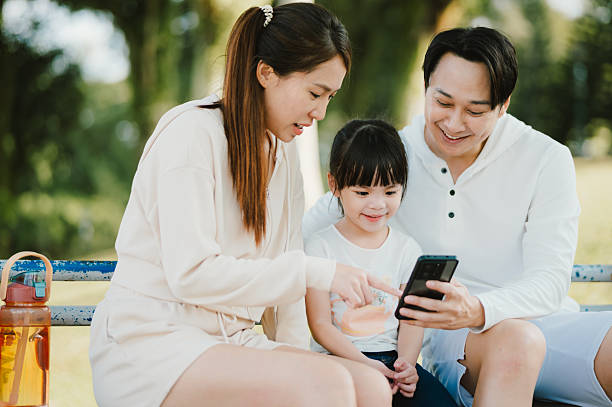 istock Family bonding time with smartphone in park 2225992341