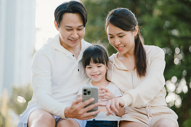 istock Shared Screen, Shared Smiles: Family Looking at Device Outdoors 2225992418