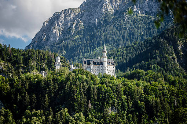 NEUSCHWANSTEIN CASTLE, BAVARIA, GERMANY - September 18, 2017: Neuschwanstein Castle stands among the forested hills of the Bavarian Alps in southern Germany. This 19th-century Romanesque Revival palace, commissioned by King Ludwig II, is one of the most visited castles in Europe and a symbol of romantic architecture.