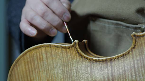 istock Luthier is applying a special varnish on a new violin with a small tool, making it look older and more valuable, a technique called antiquing 2225994850