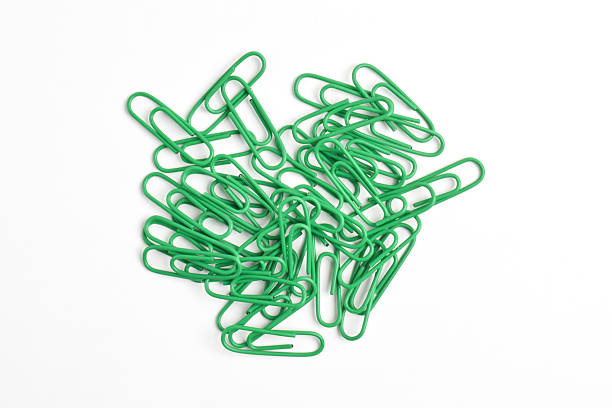 Many green paper clips isolated on white background