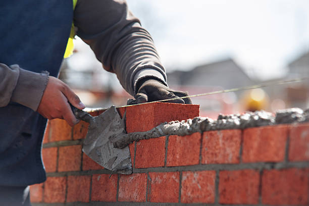 istock Industrial bricklayer laying bricks and concrete blocks on cement mix mortar on construction site 2226000149