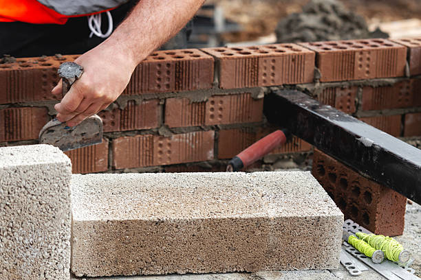 istock Builder cutting concrete block with chisel and hammer to right size 2226003315