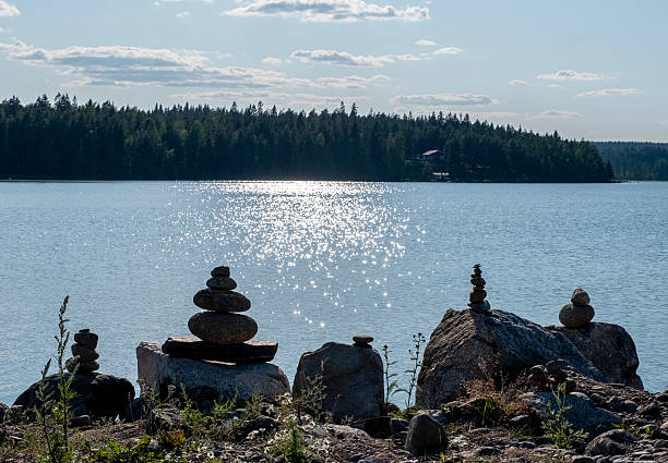 Balance, stability concept. Stones pebbles Zen pyramid of balance standing on stable base is flowing by sea waves Meditation and relaxation practice on beach