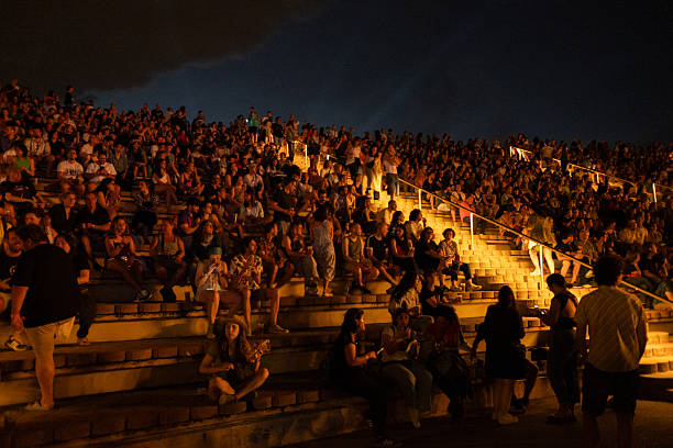 Barcelona, España July 12, 2025. Large group of spectators enjoying an outdoor night event, sitting together on illuminated bleachers, surrounded by vibrant lights and excitement in Cruïlla Festival, Barcelona.