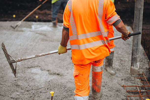 istock Construction worker operating a concrete pump at a job site in the daytime, focusing on the pouring process and surrounding activity 2226004532