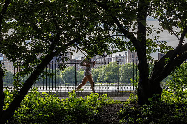 New York, New York, USA May  23, 2025 A woman jogger at the reservoir  in Central Park.