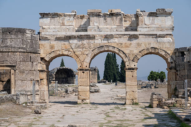 Visitors admire the ancient structures and unique landscape of Pamukkale, a UNESCO World Heritage site known for its rich history and thermal pools.
