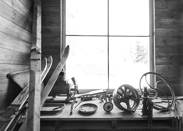 Interior image of implements and tools on a table in one of the still-intact buildings at Garnet Ghost Town in Montana, U.S.A, photographed in black and white during a summer day