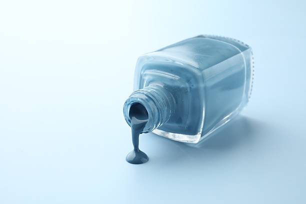 Nail polish bottle on blue background. Copyspace