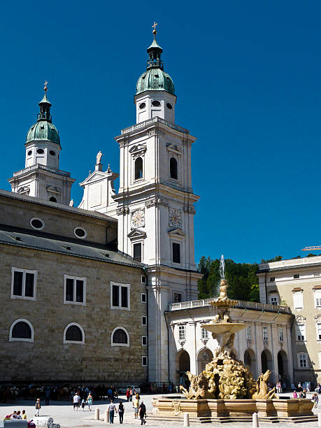 Salzburg, Austria - June 21, 2012. Residenzplatz square in Salzburg, Austria. View with the baroque Dom and Residenzbrunnen fountain and people. Originally named Hauptplatz, it is now named after the Alte Residenz (Old Residence) of the Prince-Archbishops of Salzburg. It is one of the city's most popular places to visit.