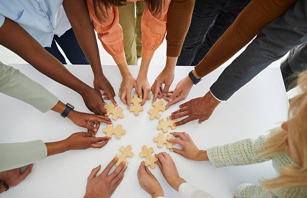 istock Hands of different business people connecting puzzle pieces as sign of problem solving and teamwork. 2226039122