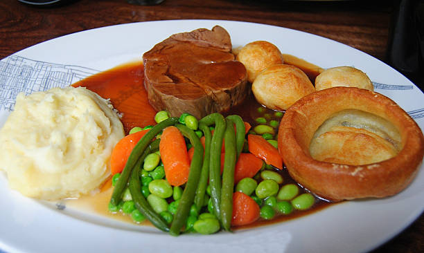 istock Roast beef with vegetables, mashed potatoes, Yorkshire pudding, and gravy on white plate 2226040392