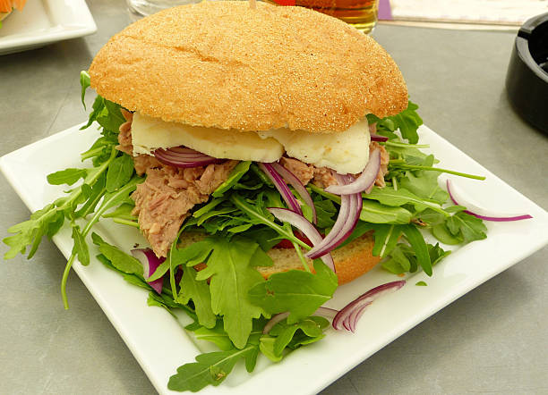 Sandwich with tuna fish, cheese, onions and rucola.
