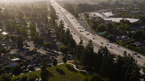 istock Highway traffic flows through San Jose, California. Busy multi-lane freeway cuts through residential neighborhood during afternoon commute. 2226042971