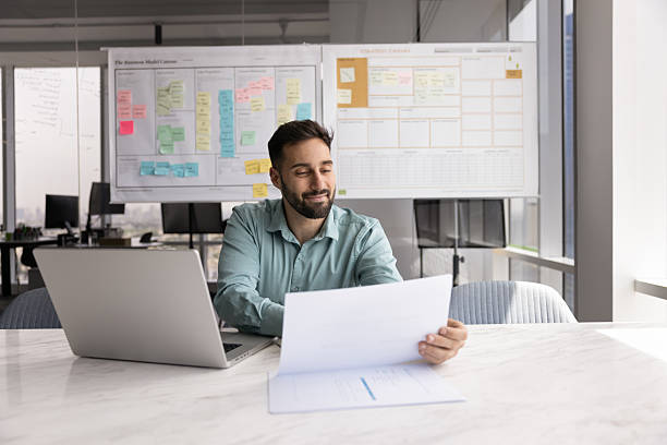 istock Smiling Hispanic man reviewing documents or financial report 2226044529