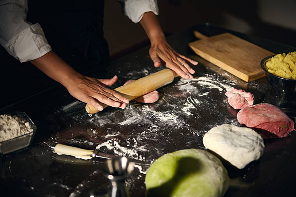 Cooking Scene Featuring Chef Preparing Dough on a Kitchen Counter with Rolling Pin