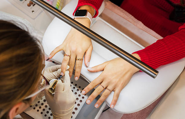 Spa artist applying nail polish to client.