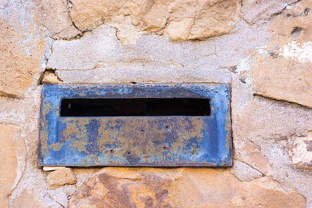 Rusty Mail Slot in Old Stone Wall