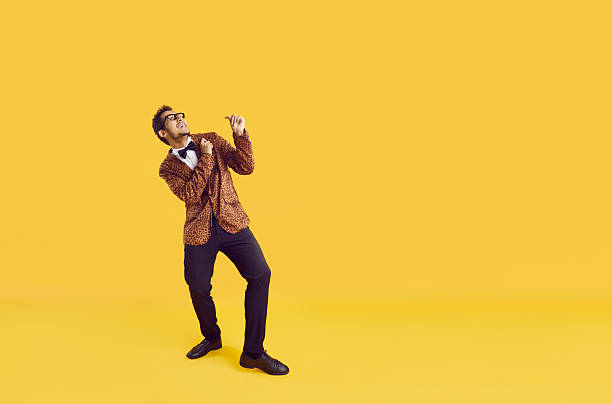 istock Happy funny man in leopard jacket dancing and looking up on yellow copy space background 2226066895