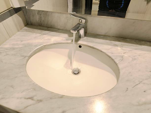 Clear water flowing into a white sink, representing cleanliness and hygiene