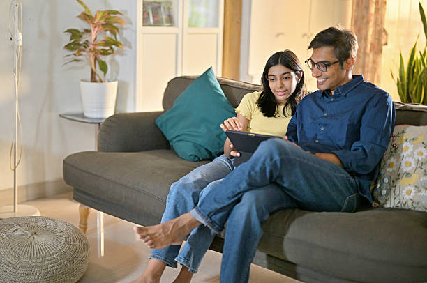 istock Father and Daughter Sharing a Tablet on the Sofa at home 2226088597
