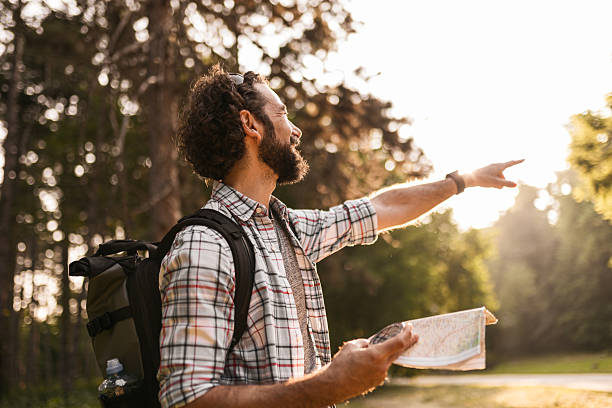 istock Male Hiker Navigating Route with Paper Map And Compass 2226089344