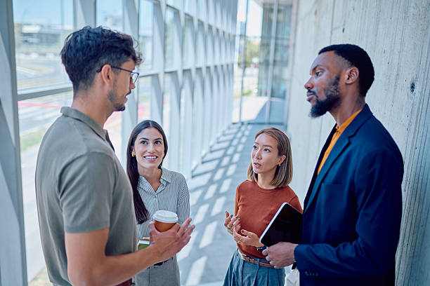 istock Business team discussing during a coffee break in modern office hallway 2226096026