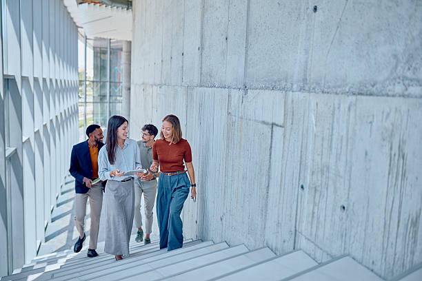 istock Diverse businesspeople walking up stairs in modern office building 2226096049