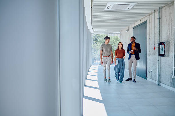 istock Businesspeople walking and talking in modern office hallway 2226096287