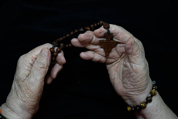 istock My mother is praying the rosary.  . 2226096874