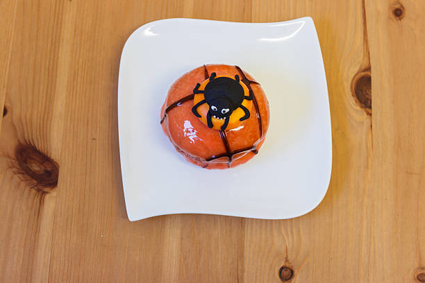 Close up large orange pumpkin cake, surrounded by halloween ghost and cup cakes, Halloween decorations