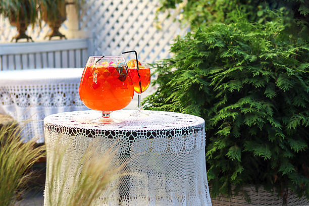 istock Bright orange beverage glass on a lace-covered table in a garden setting 2226103501
