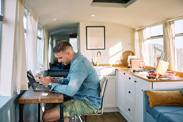 istock Man Relaxing Working on Laptop and Typing on Cellphone 2226108639