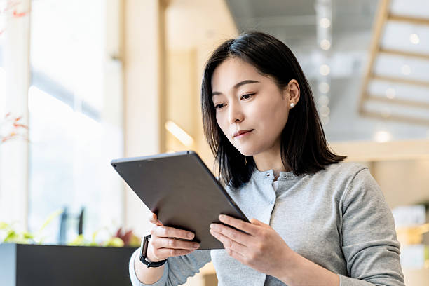 istock An Asian woman using a tablet in a coffee shop 2226109032
