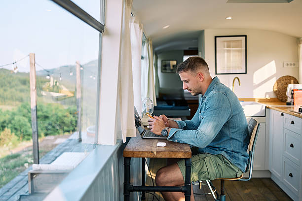 istock Man Working on Laptop in Bright Vacation Kitchen 2226109090