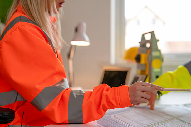 istock Engineering professionals collaborate on construction plans in bright office wearing safety hi-viz gear 2226112537