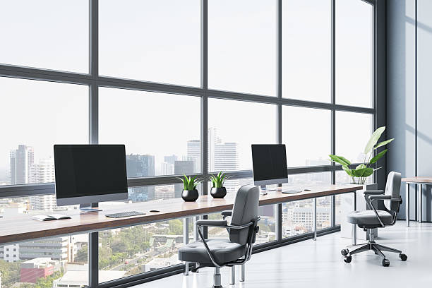 istock Modern empty office interior with minimalistic furniture and panoramic city view through large glass windows on a bright sunny day. 3D Rendering 2226112605