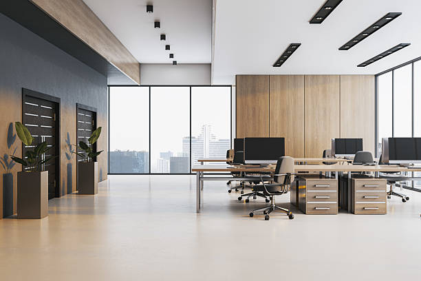 istock Modern empty office interior with wooden wall panels, shared desks, and city view through large windows in bright coworking workspace. 3D Rendering 2226112636