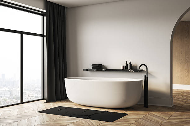 istock Modern minimalist bathroom interior with white bathtub and city view through large window, black fixtures and cozy wooden floor design. 3D Rendering 2226112751