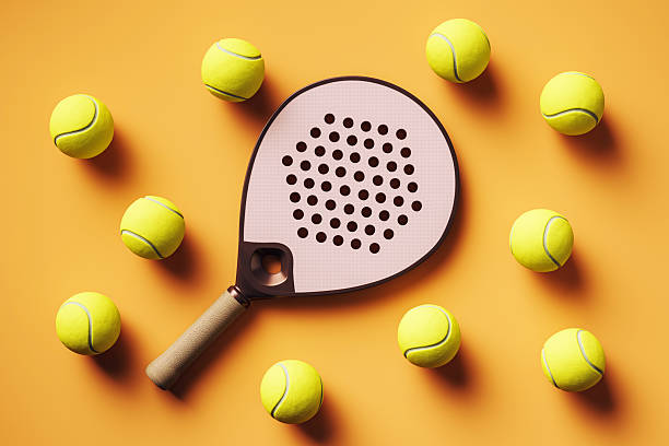 istock Padel racket with scattered yellow balls on orange background, captured from top view with stylish minimal design concept for sport and leisure. 3D Rendering 2226112834
