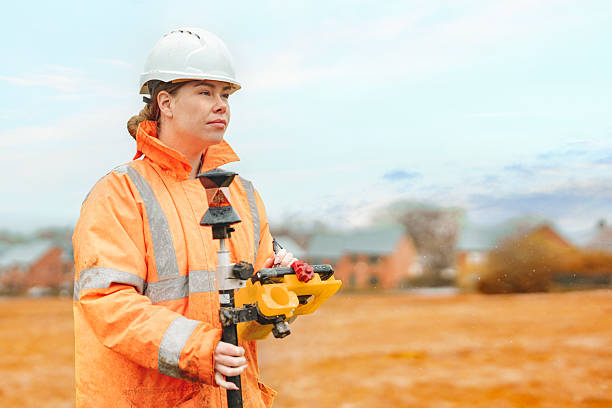 istock Female builder land surveyor working under rain on construction site 2226113085