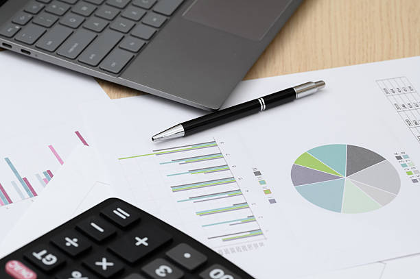 istock Finance, counting on a calculator, papers with financial documentation lying on the desk, charts, tables and business data 2226117768