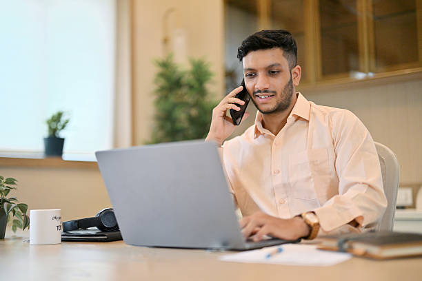 istock Man talking on phone While Working on His Laptop from home 2226117947