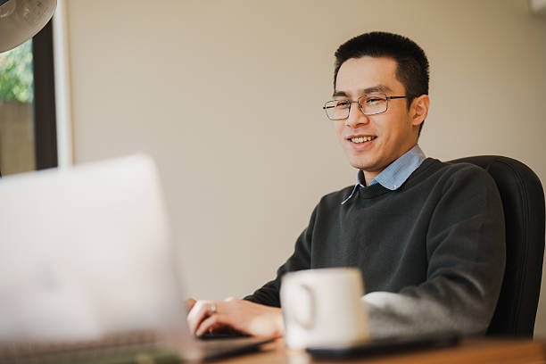 istock Happy young Asian man typing confidently in a home workspace 2226118124