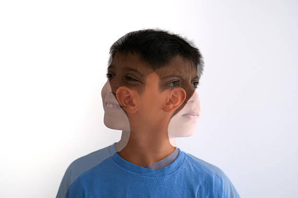 Artistic double exposure photo of a young boy in a blue shirt, with overlapping facial expressions looking in different directions. The composite image blends a smile, neutral gaze, and a thoughtful look, symbolizing emotional complexity, inner conflict, or the multifaceted nature of identity. Captured against a clean white background for maximum versatility in conceptual and editorial use.