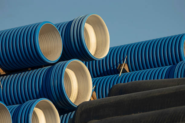 istock A tall stack of blue and black pipes standing against a clear blue sky 2226123694
