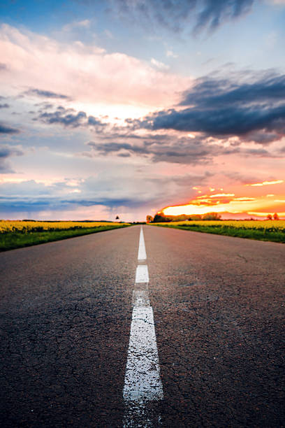 istock Empty road through countryside in springtime sunset, traveling and transportation concept, country road in diminishing perspective 2226127524