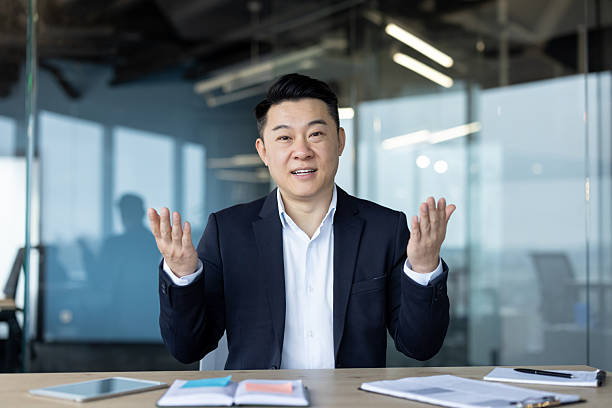 istock Asian businessman in a suit gesturing with hands during a presentation in the office setting. 2226129068