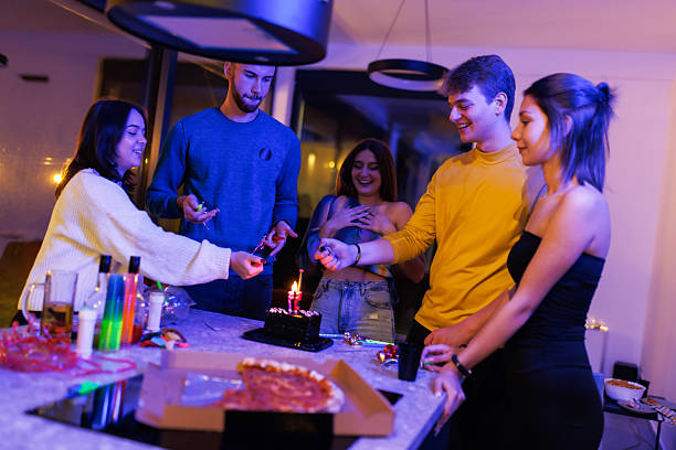 Group of young friends celebrating birthday party at home in joyful atmosphere